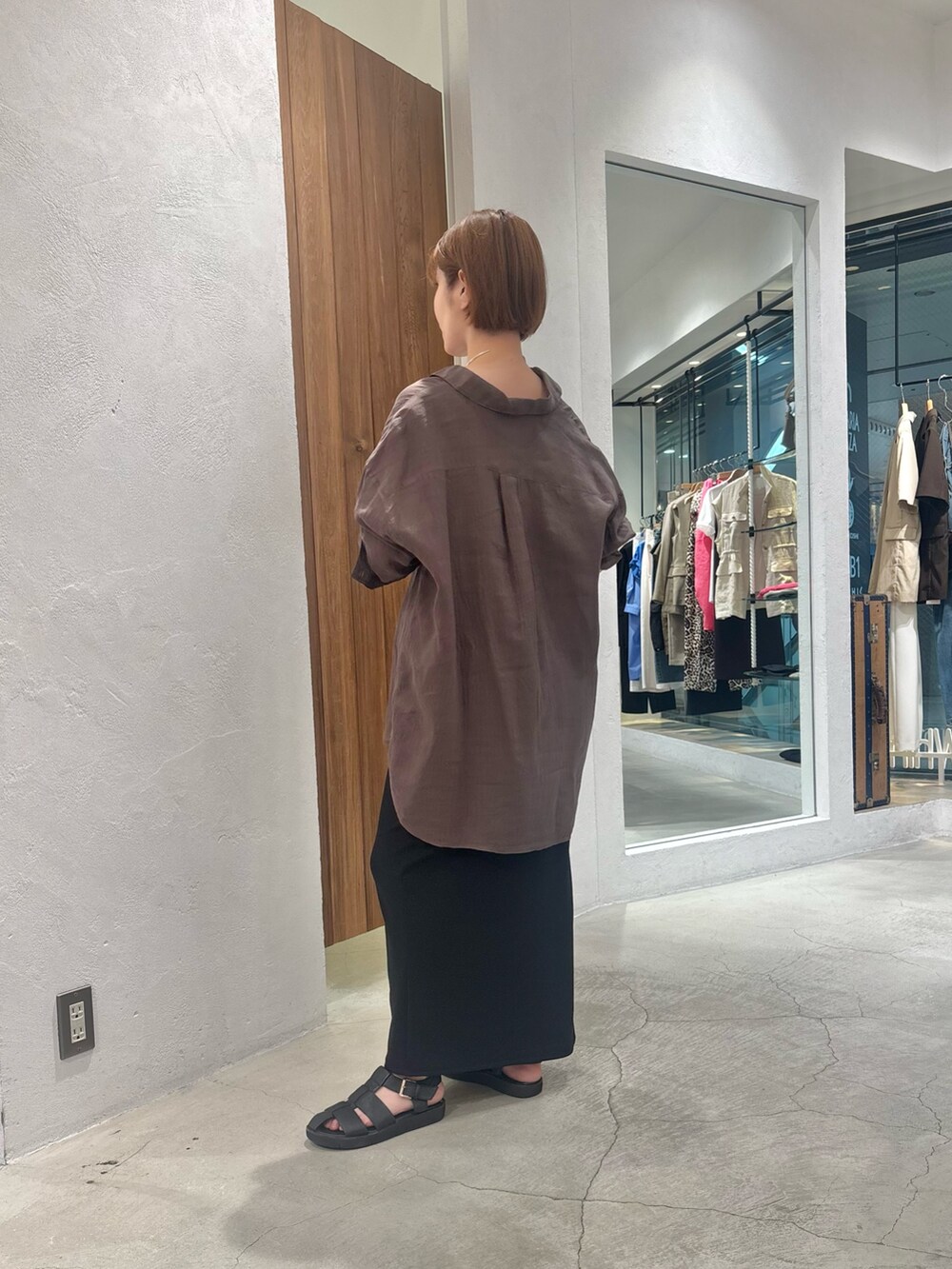 ブラック系のキャミソール、ブラック系のスカート、ブラック系のサンダルを着用したレディースの夏コーディネートの2枚目の写真