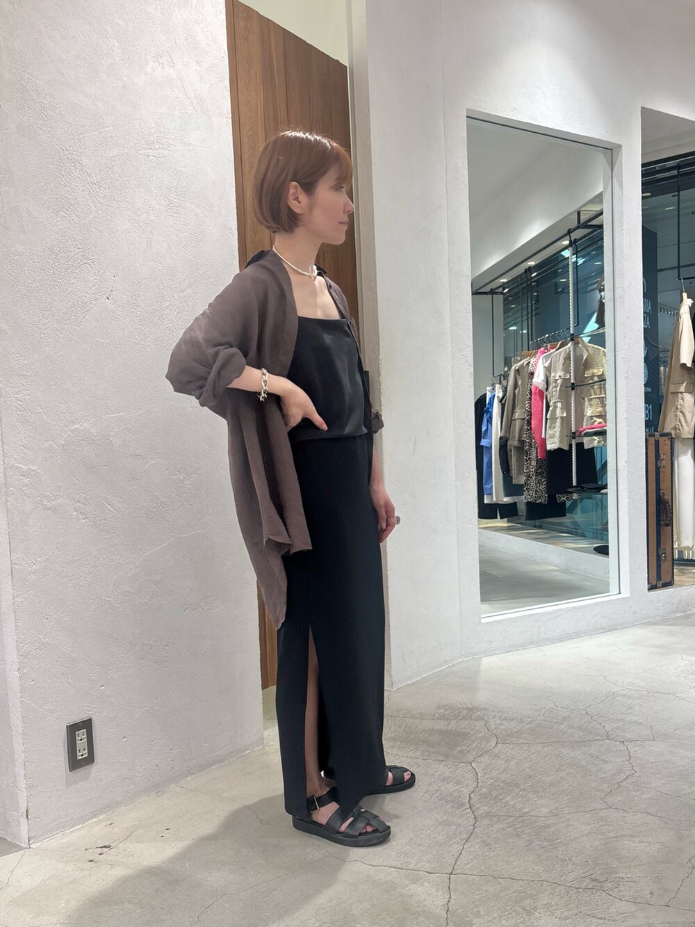 ブラック系のキャミソール、ブラック系のスカート、ブラック系のサンダルを着用したレディースの夏コーディネートの3枚目の写真