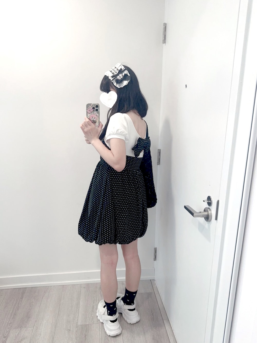 ホワイト系のサンダル、ブラック系のトートバッグを着用したレディースの夏コーディネートの2枚目の写真