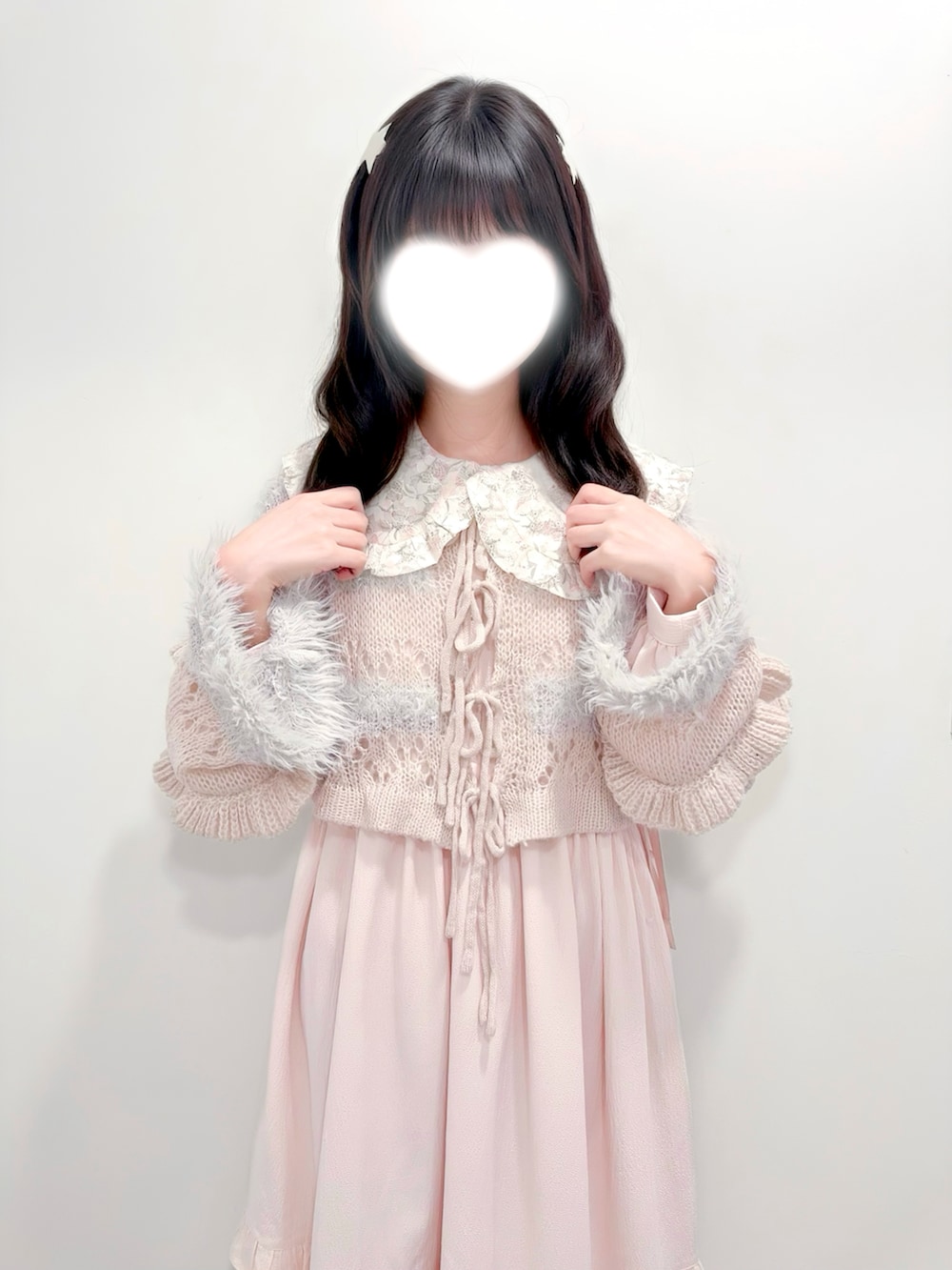 グレー系のカーディガン/ボレロ、ピンク系のワンピース、ホワイト系のスニーカーを着用したレディースの冬コーディネートの3枚目の写真