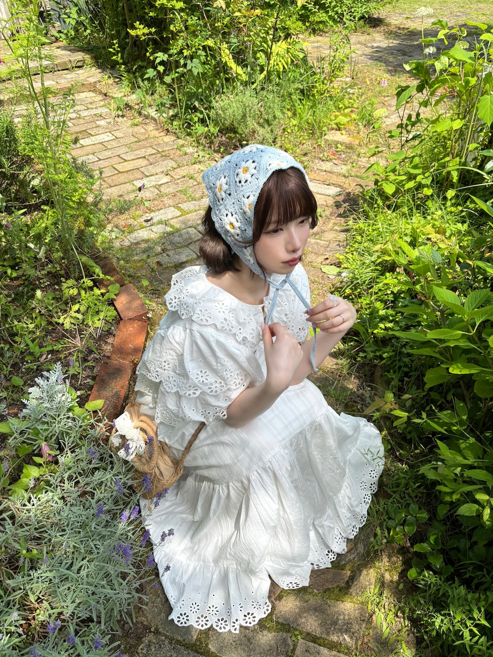 ホワイト系のワンピース、ベージュ系のバッグ、ベージュ系のサンダルを着用したレディースの夏コーディネートの2枚目の写真