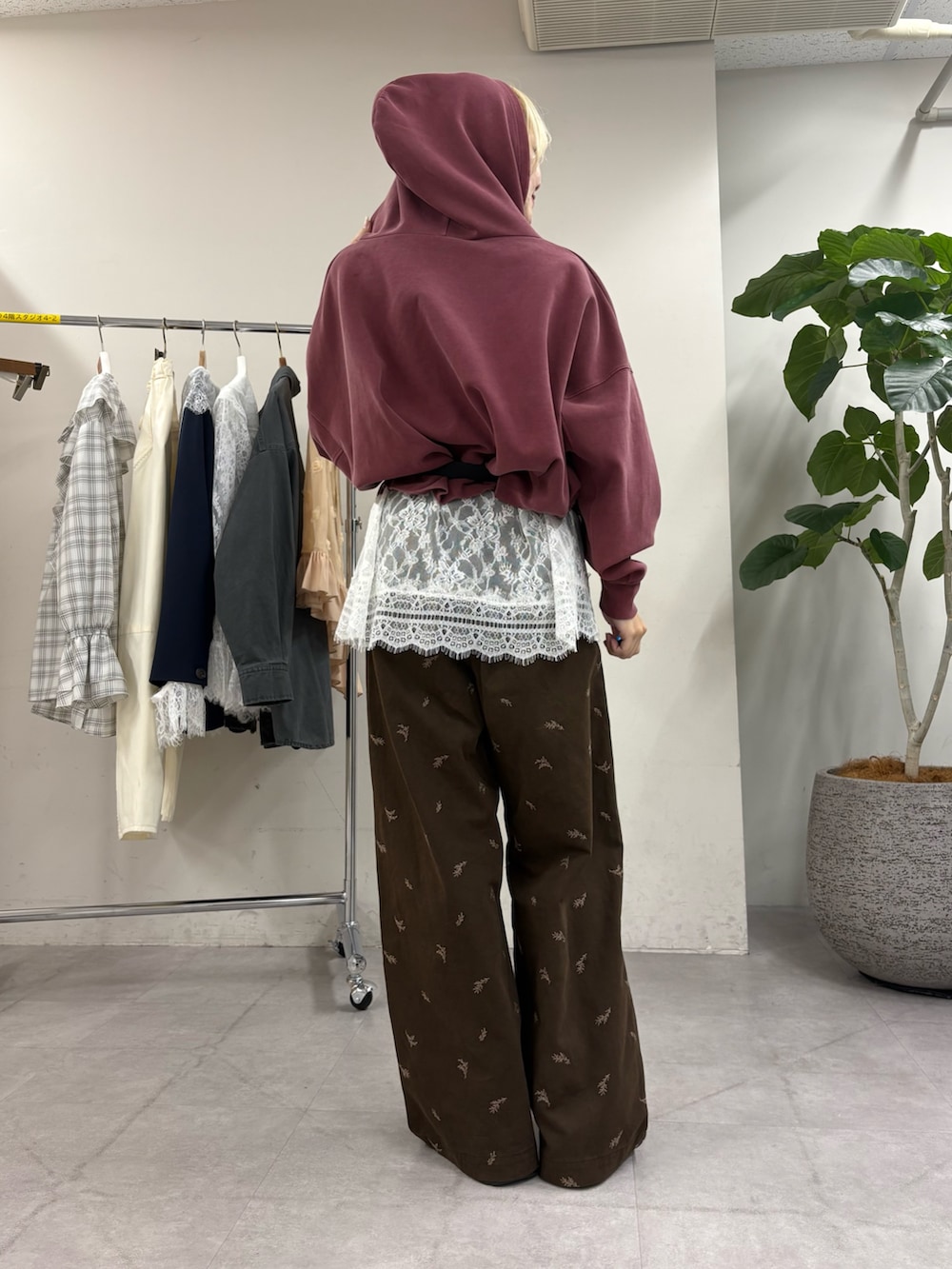 レッド系のパーカー、ホワイト系のチュニック、ブラウン系のTシャツ/カットソーを着用したレディースの秋コーディネートの3枚目の写真
