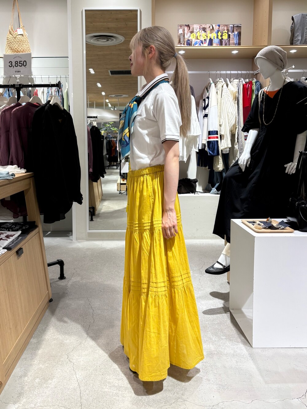 ホワイト系のポロシャツ、イエロー系のスカート、グリーン系のバンダナ/スカーフを着用したレディースの夏コーディネートの2枚目の写真