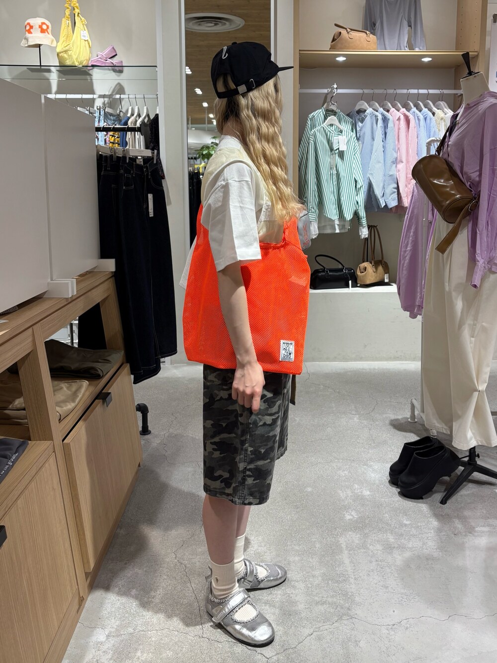 ホワイト系のベスト、ホワイト系のTシャツ/カットソー、オレンジ系のトートバッグを着用したレディースの夏コーディネートの4枚目の写真