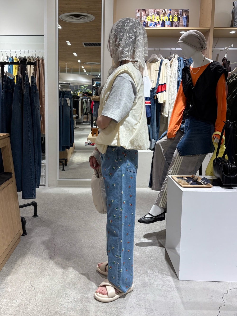 ホワイト系のベスト、グレー系のTシャツ/カットソー、ブルー系のデニムパンツを着用したレディースの夏コーディネートの2枚目の写真