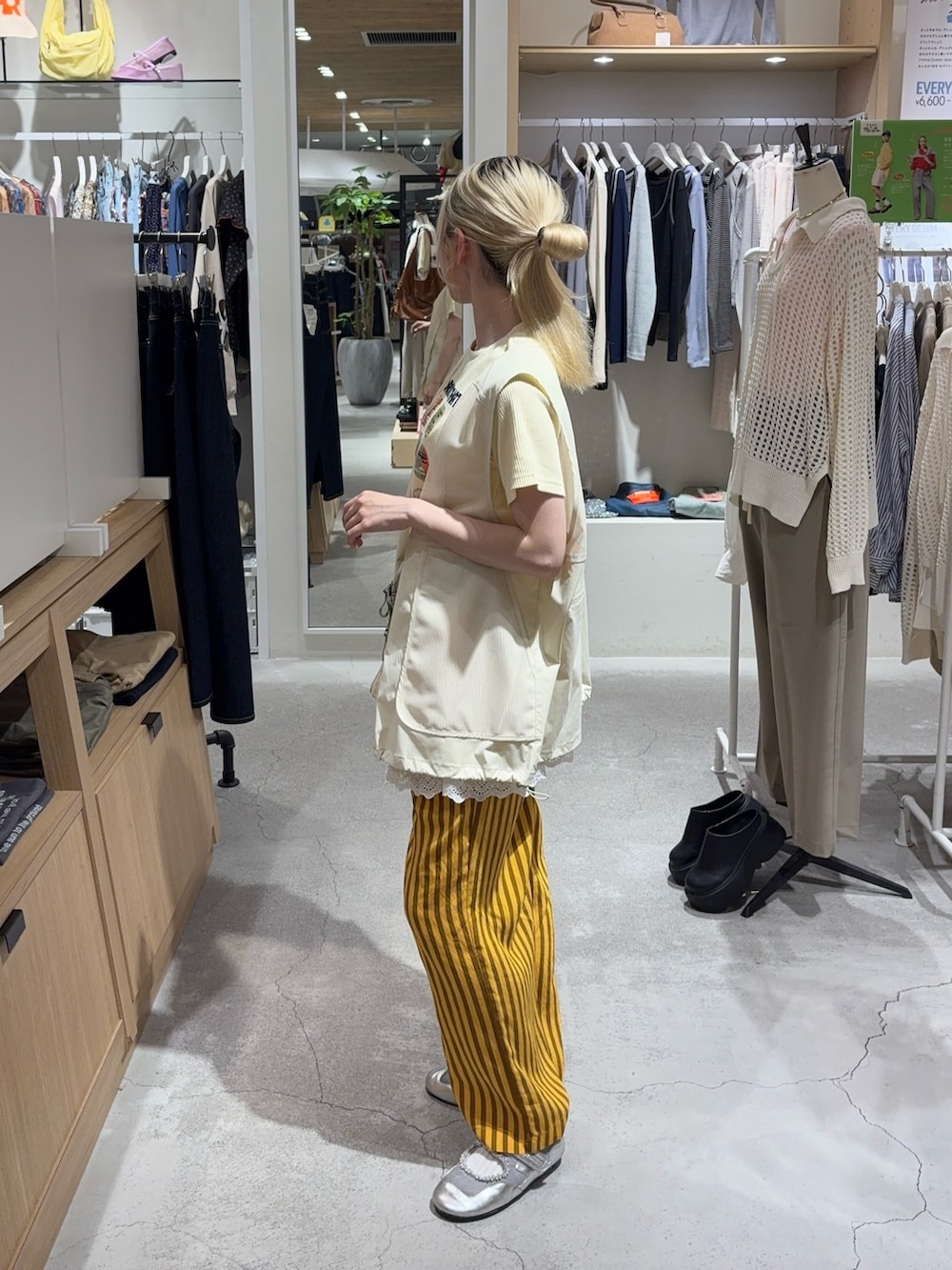 イエロー系のTシャツ/カットソー、ホワイト系のベスト、グリーン系のボディバッグ/ウエストポーチを着用したレディースの春コーディネートの4枚目の写真