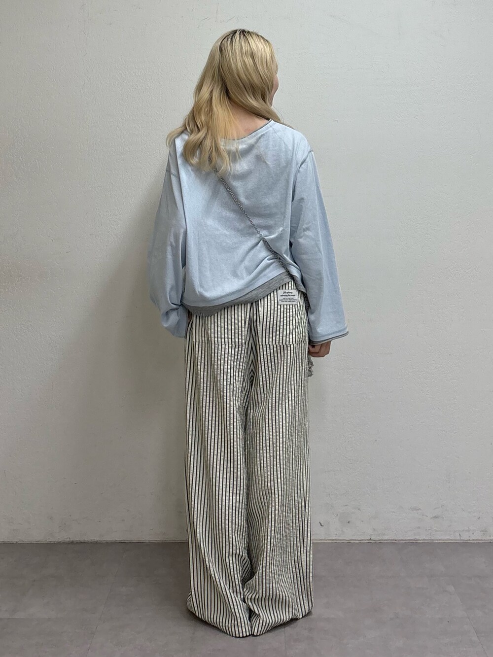ブルー系のTシャツ/カットソー、シルバー系のショルダーバッグ、ホワイト系のその他パンツを着用したレディースの春コーディネートの3枚目の写真