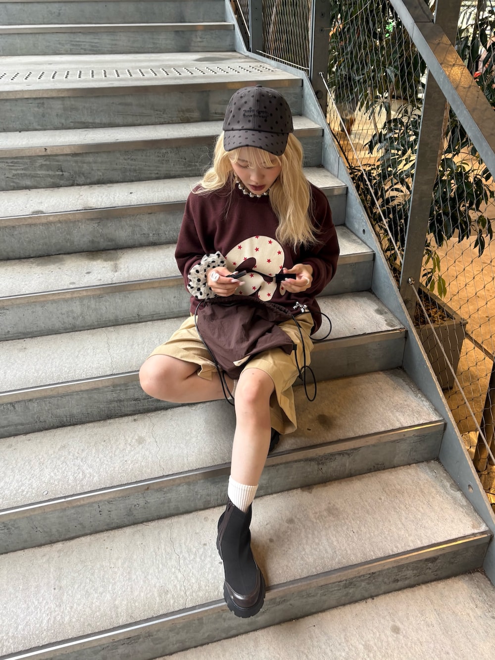 レッド系のTシャツ/カットソー、ベージュ系のその他パンツ、ブラック系のブーツを着用したレディースの夏コーディネートの2枚目の写真