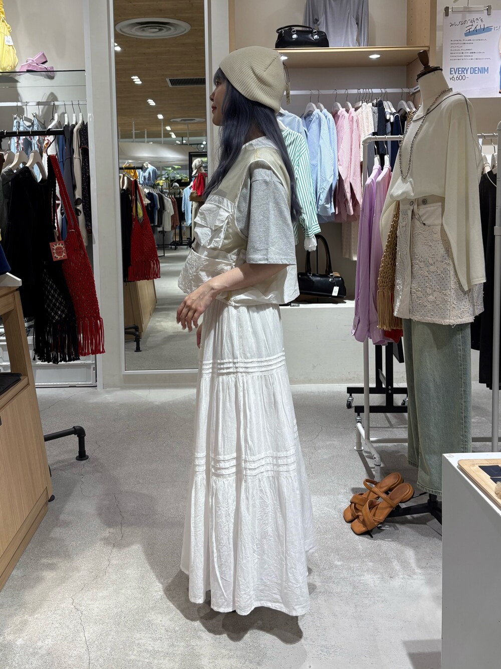 ホワイト系のベスト、グレー系のTシャツ/カットソー、ホワイト系のスカートを着用したレディースの夏コーディネートの2枚目の写真