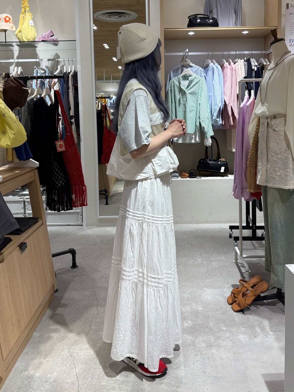 ホワイト系のベスト、グレー系のTシャツ/カットソー、ホワイト系のスカートを着用したレディースの夏コーディネートの4枚目の写真