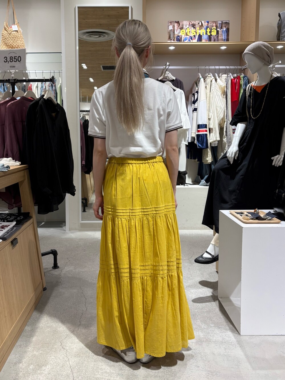 ホワイト系のポロシャツ、イエロー系のスカート、グリーン系のバンダナ/スカーフを着用したレディースの夏コーディネートの3枚目の写真