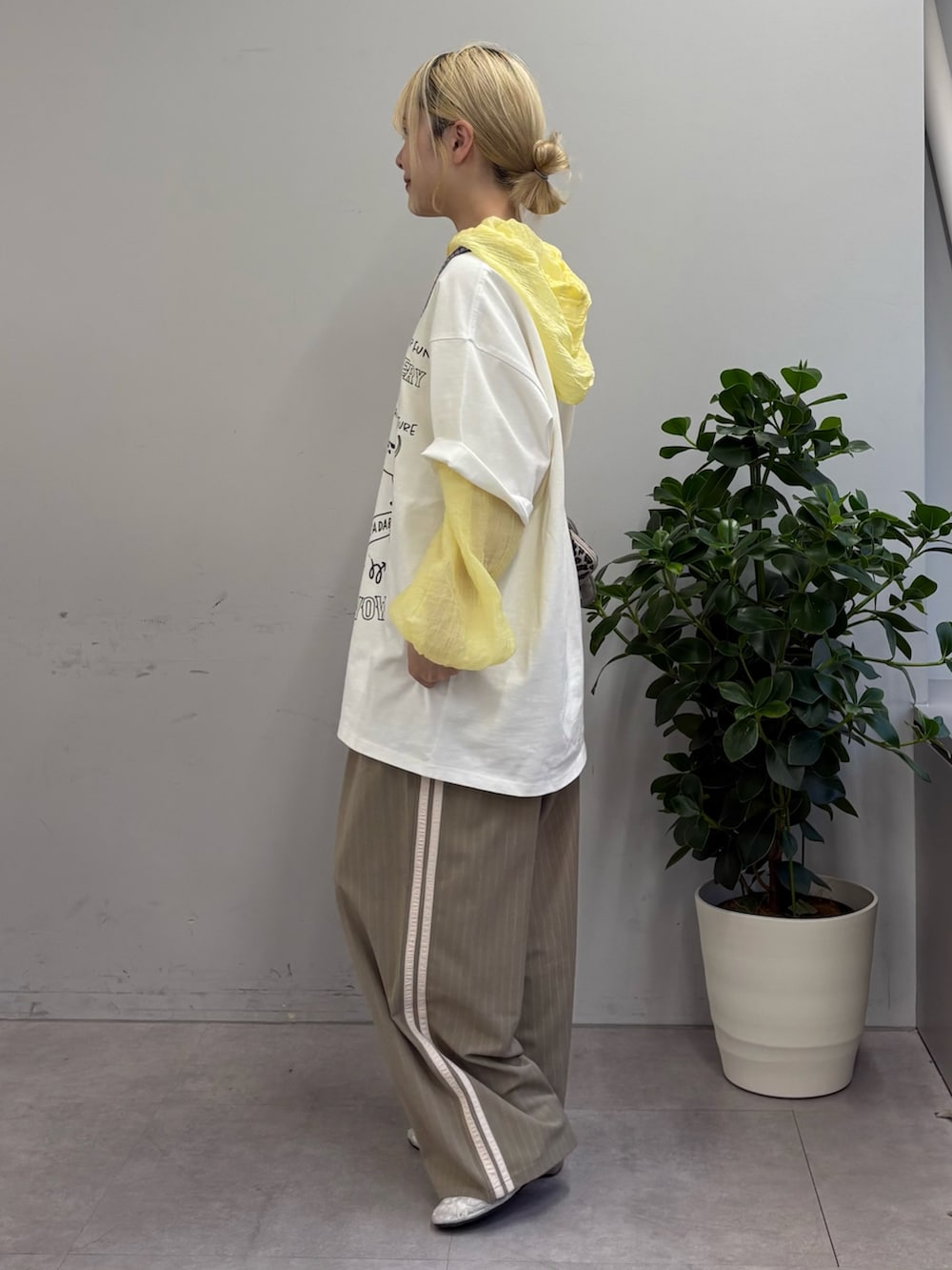 ホワイト系のTシャツ/カットソー、イエロー系のシャツ/ブラウス、ベージュ系のスラックスを着用したレディースの夏コーディネートの2枚目の写真
