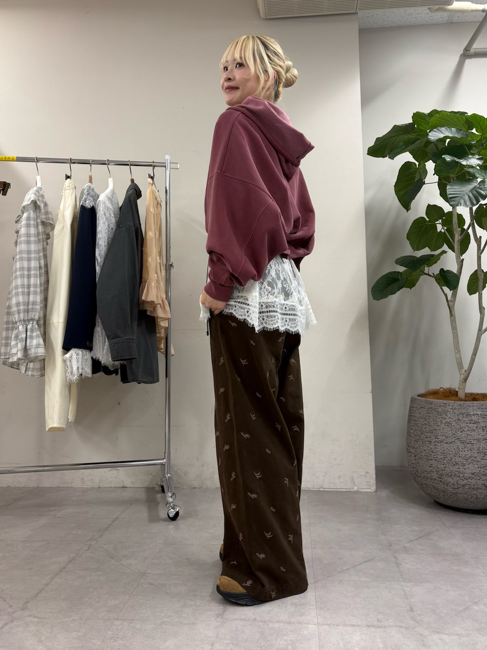 レッド系のパーカー、ホワイト系のチュニック、ブラウン系のTシャツ/カットソーを着用したレディースの秋コーディネートの2枚目の写真