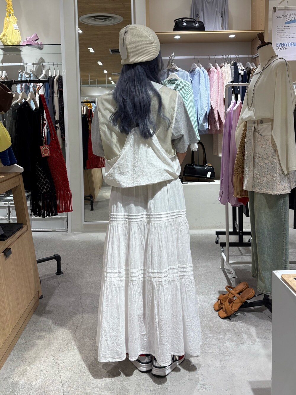 ホワイト系のベスト、グレー系のTシャツ/カットソー、ホワイト系のスカートを着用したレディースの夏コーディネートの3枚目の写真