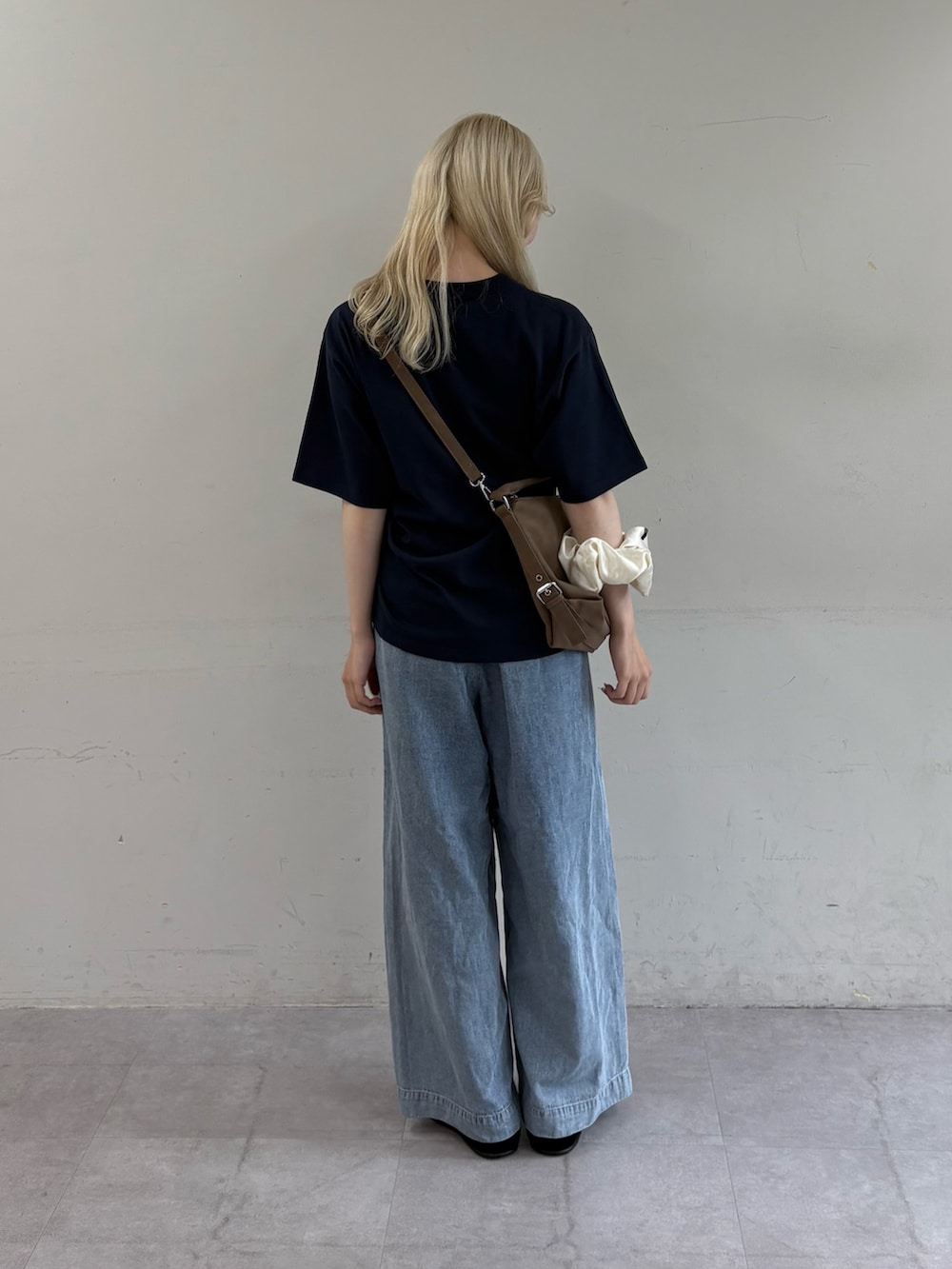 ブルー系のTシャツ/カットソー、ベージュ系のショルダーバッグ、ブルー系のデニムパンツを着用したレディースの夏コーディネートの3枚目の写真
