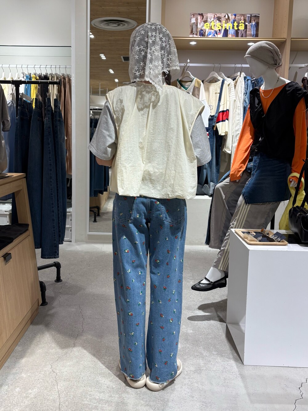 ホワイト系のベスト、グレー系のTシャツ/カットソー、ブルー系のデニムパンツを着用したレディースの夏コーディネートの3枚目の写真