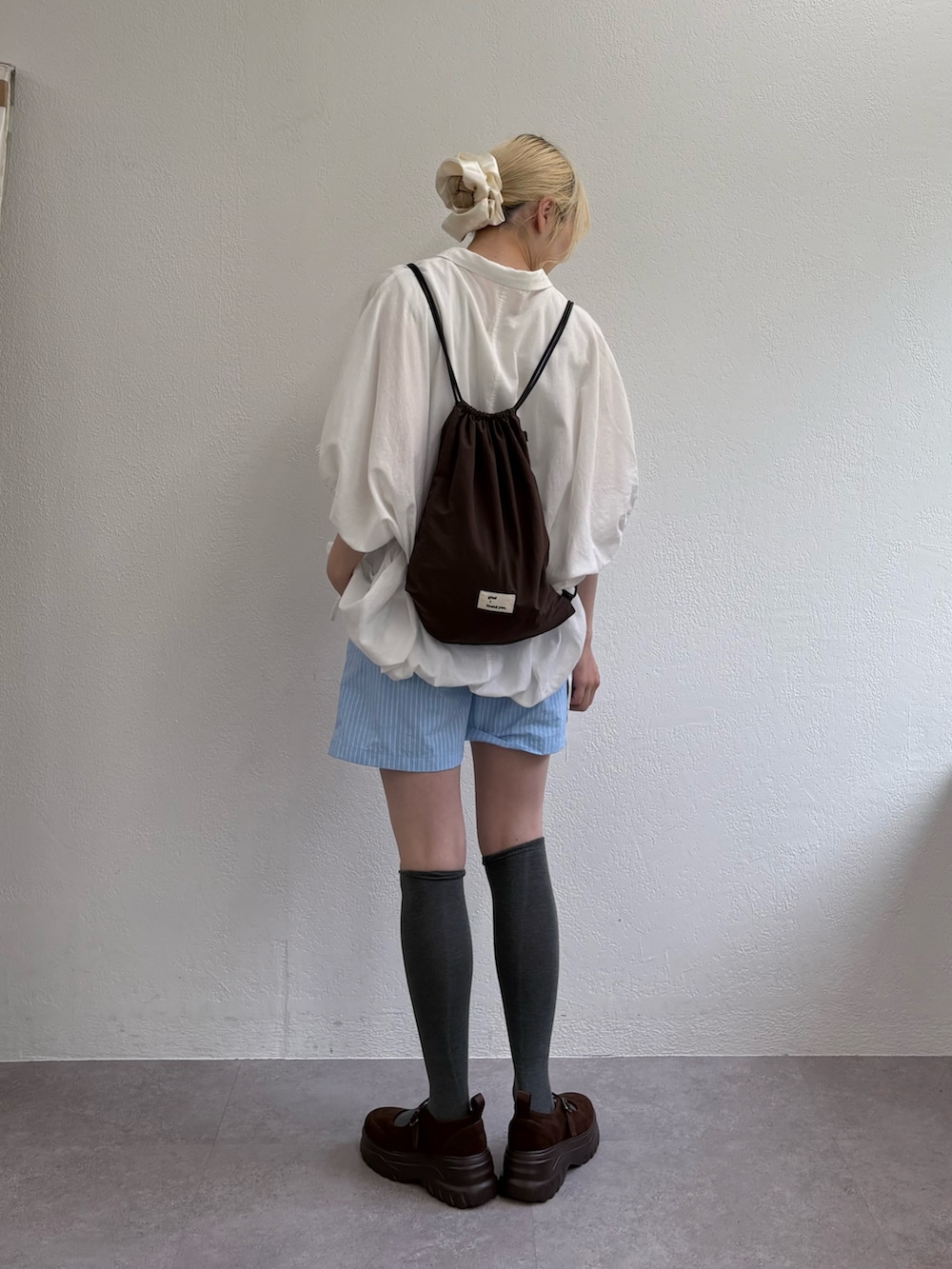 ブルー系のその他パンツ、ホワイト系のシャツ/ブラウス、ブラウン系のパンプスを着用したレディースの夏コーディネートの2枚目の写真