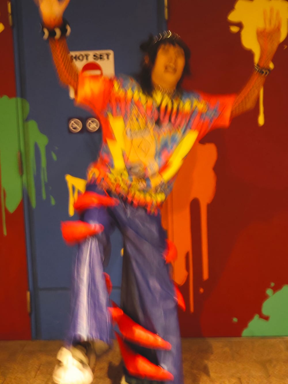 ブラック系のスニーカー、その他のTシャツ/カットソー、オレンジ系のその他トップスを着用したメンズの秋コーディネートの3枚目の写真