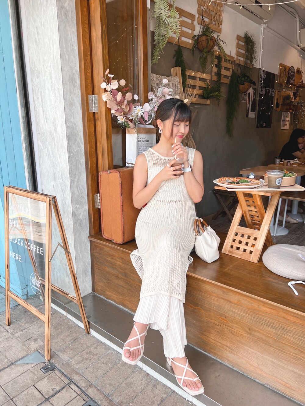 ホワイト系のジャンパースカート、ベージュ系のチューブトップ、ベージュ系のサンダルを着用したレディースの夏コーディネートの2枚目の写真