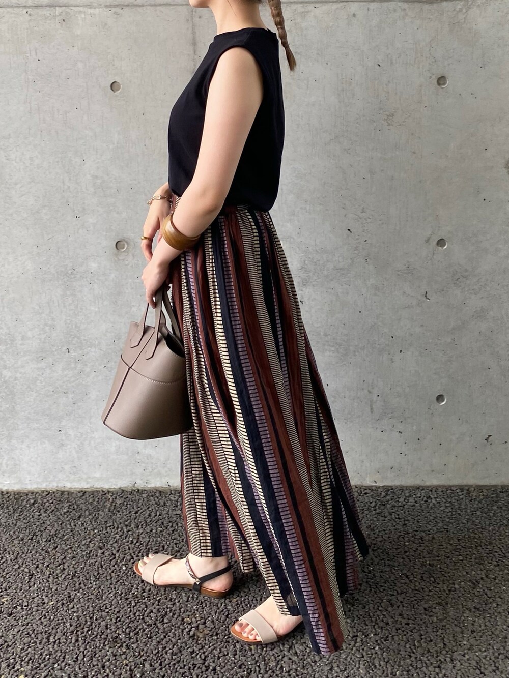 ブラック系のTシャツ/カットソー、ブラウン系のスカート、ブラウン系のハンドバッグを着用したレディースの夏コーディネートの2枚目の写真