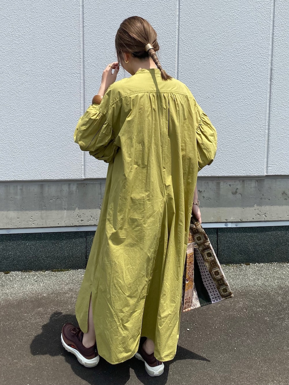 グリーン系のワンピース、その他のトートバッグ、ブラウン系のスニーカーを着用したレディースの夏コーディネートの2枚目の写真