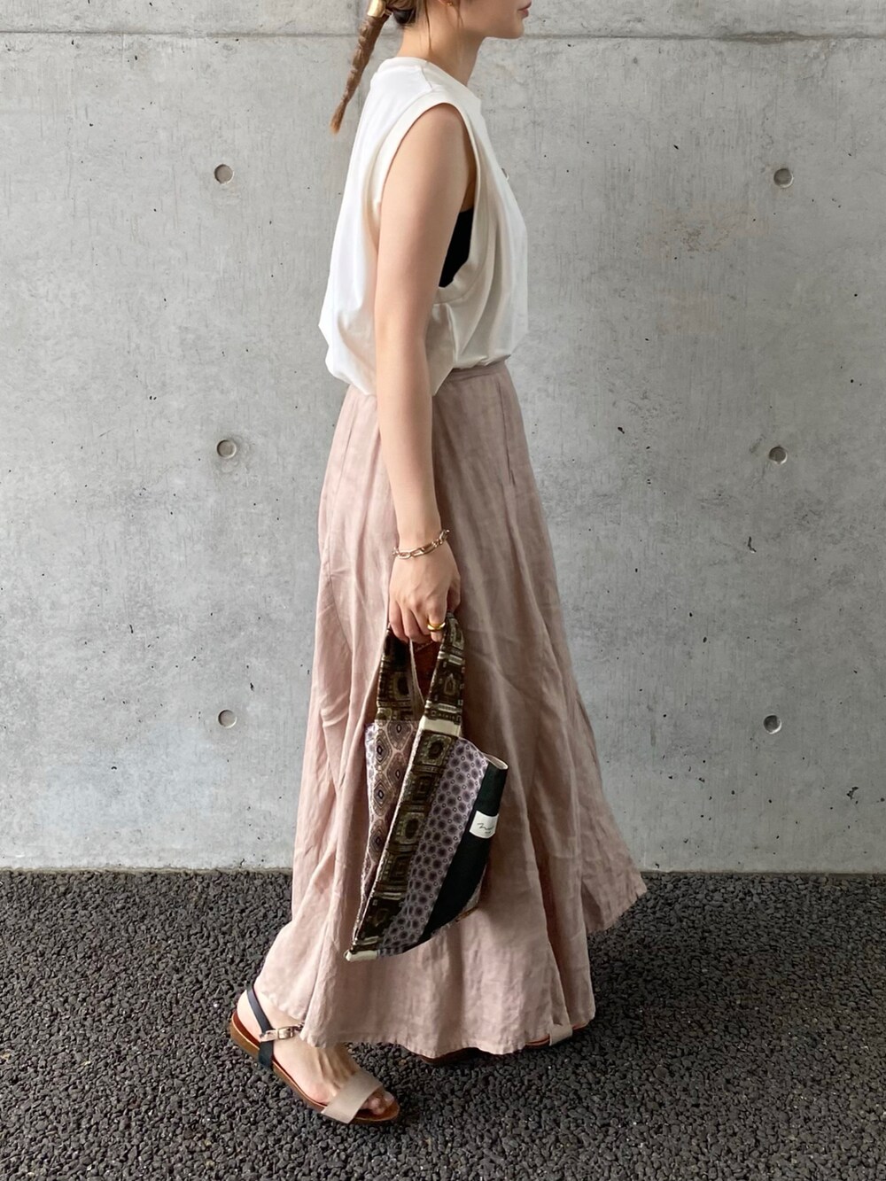 ホワイト系のTシャツ/カットソー、ベージュ系のスカート、ブラウン系のバングル/リストバンドを着用したレディースの夏コーディネートの2枚目の写真
