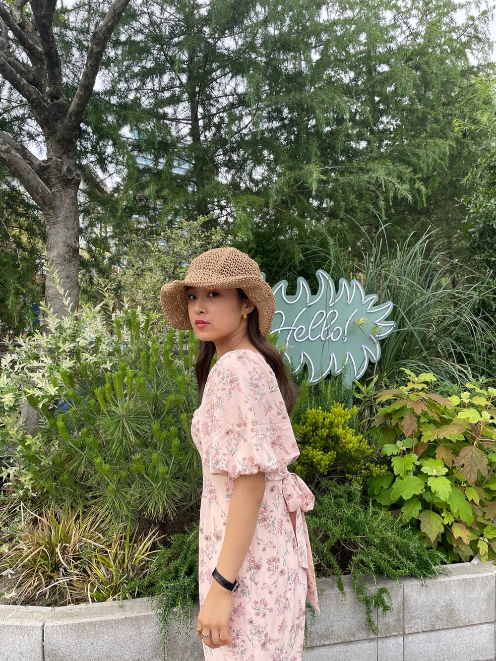 ブラック系のサンダル、ピンク系のワンピース、ベージュ系のハットを着用したレディースの春コーディネートの4枚目の写真