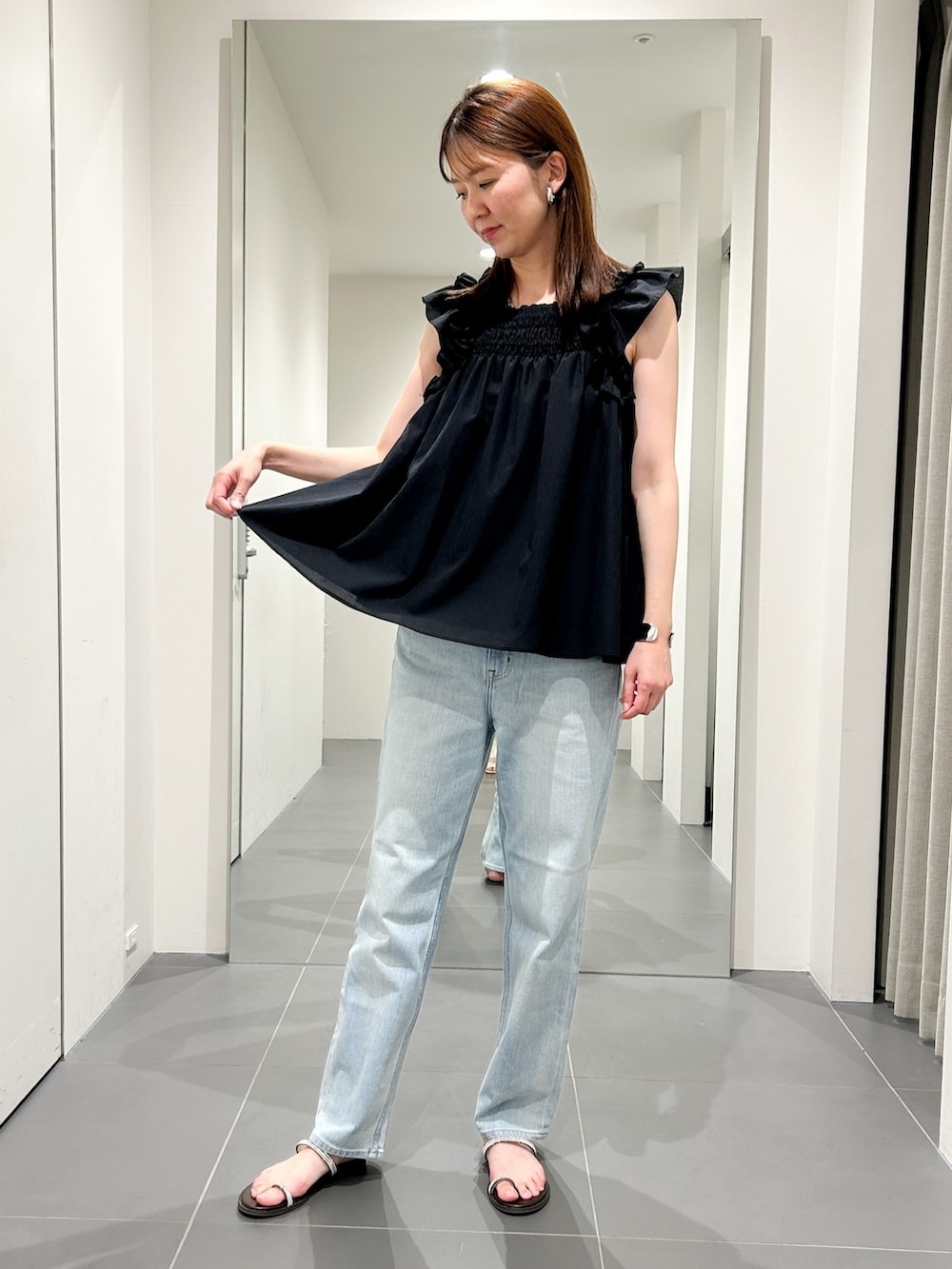 ブラック系のシャツ/ブラウス、ブルー系のデニムパンツを着用したレディースの夏コーディネートの6枚目の写真