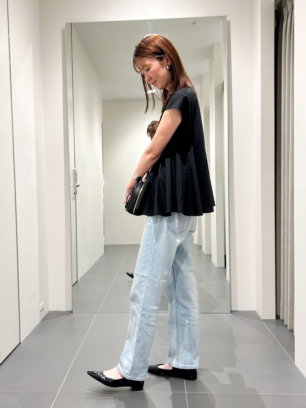 ブラック系のシャツ/ブラウス、ブルー系のデニムパンツを着用したレディースの夏コーディネートの2枚目の写真