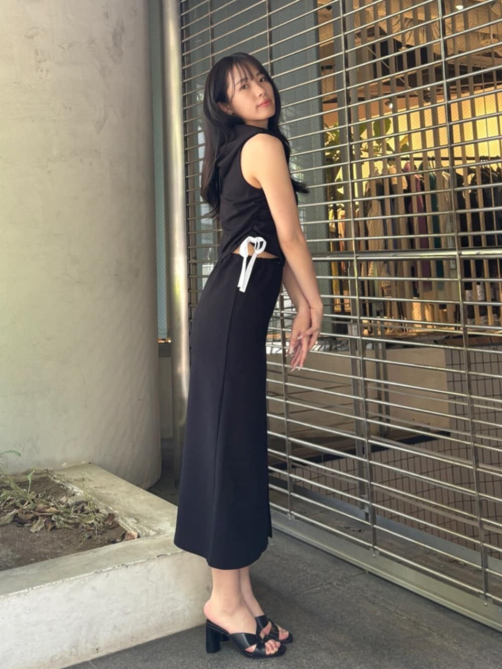 ブラック系のワンピースを着用したレディースの春コーディネートの2枚目の写真