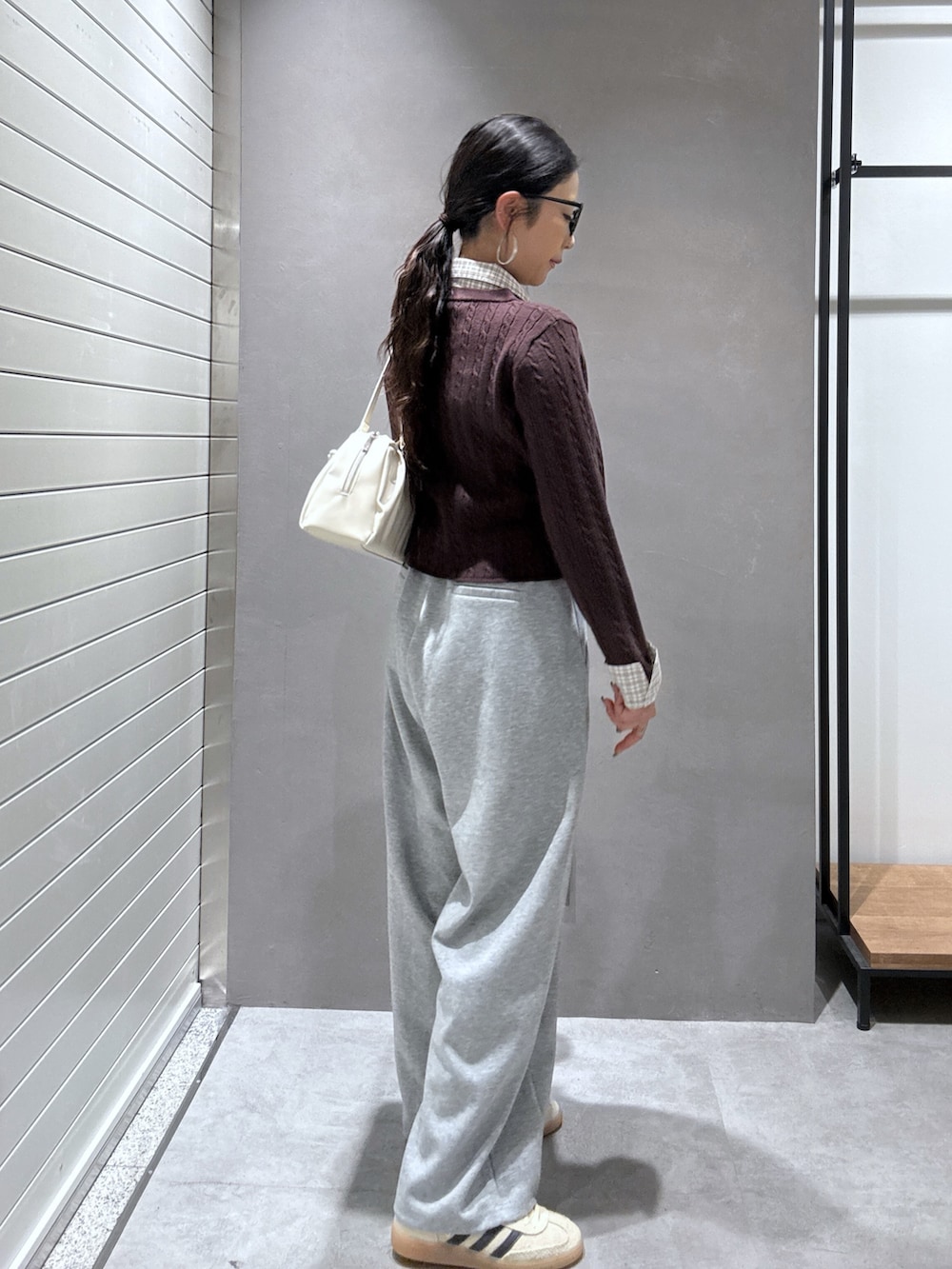 グレー系のその他パンツ、ベージュ系のスニーカー、ブラウン系のニット/セーターを着用したレディースの秋コーディネートの3枚目の写真