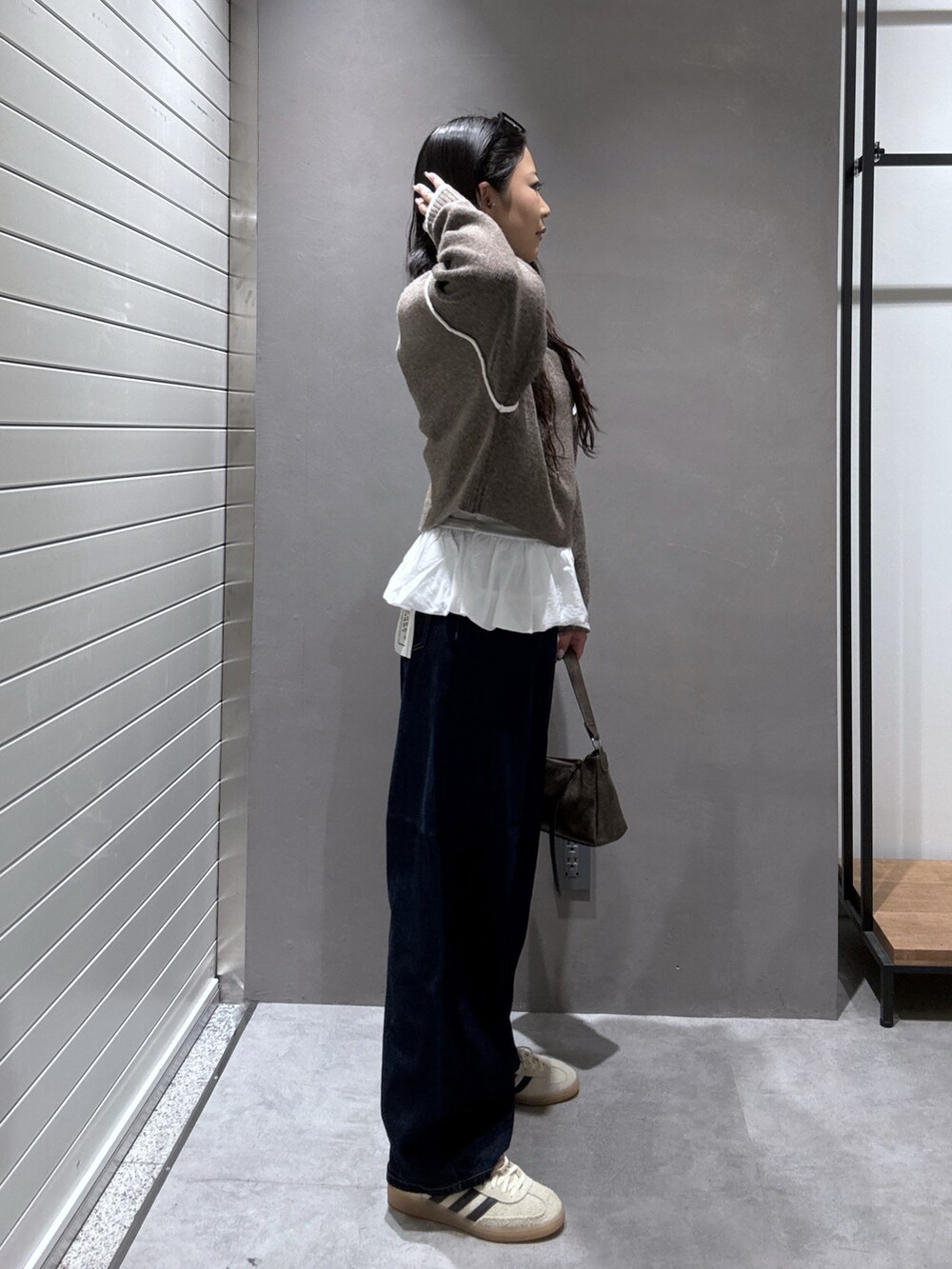 ブラウン系のニット/セーター、ブルー系のデニムパンツ、ホワイト系のTシャツ/カットソーを着用したレディースの秋コーディネートの3枚目の写真
