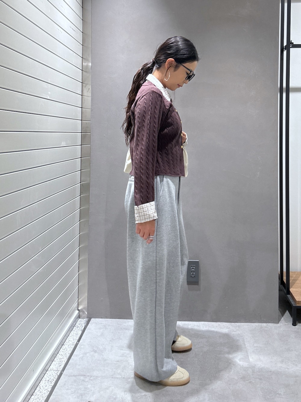 グレー系のその他パンツ、ベージュ系のスニーカー、ブラウン系のニット/セーターを着用したレディースの秋コーディネートの2枚目の写真
