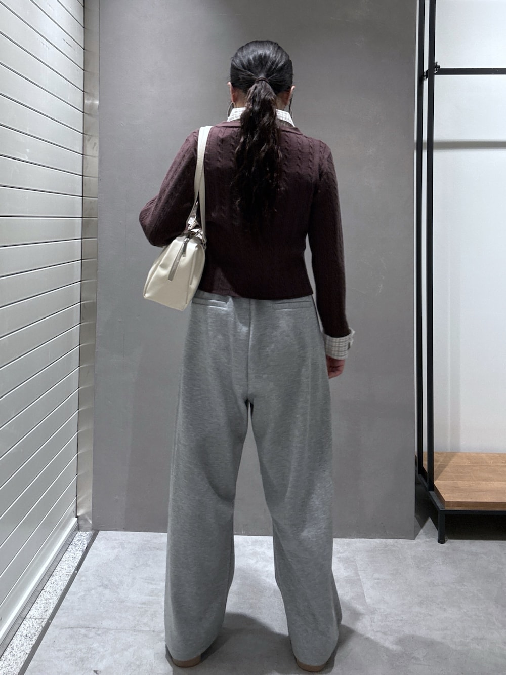 グレー系のその他パンツ、ベージュ系のスニーカー、ブラウン系のニット/セーターを着用したレディースの秋コーディネートの4枚目の写真