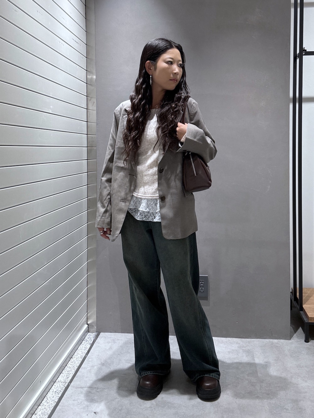 ブルー系のデニムパンツ、ベージュ系のテーラードジャケット、ブラウン系のTシャツ/カットソーを着用したレディースの秋コーディネートの4枚目の写真
