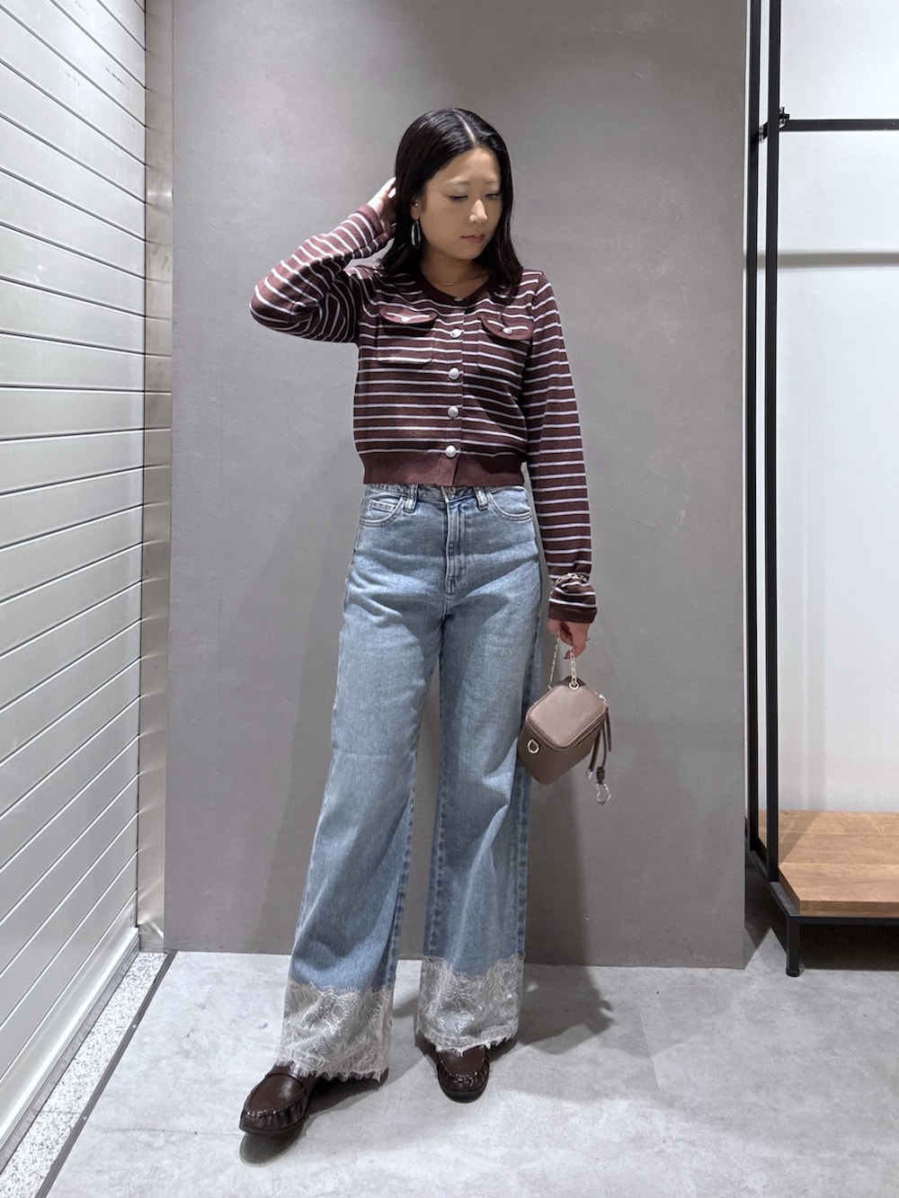 ブルー系のデニムパンツ、ブラウン系のニット/セーター、ブラウン系のローファーを着用したレディースの秋コーディネートの5枚目の写真