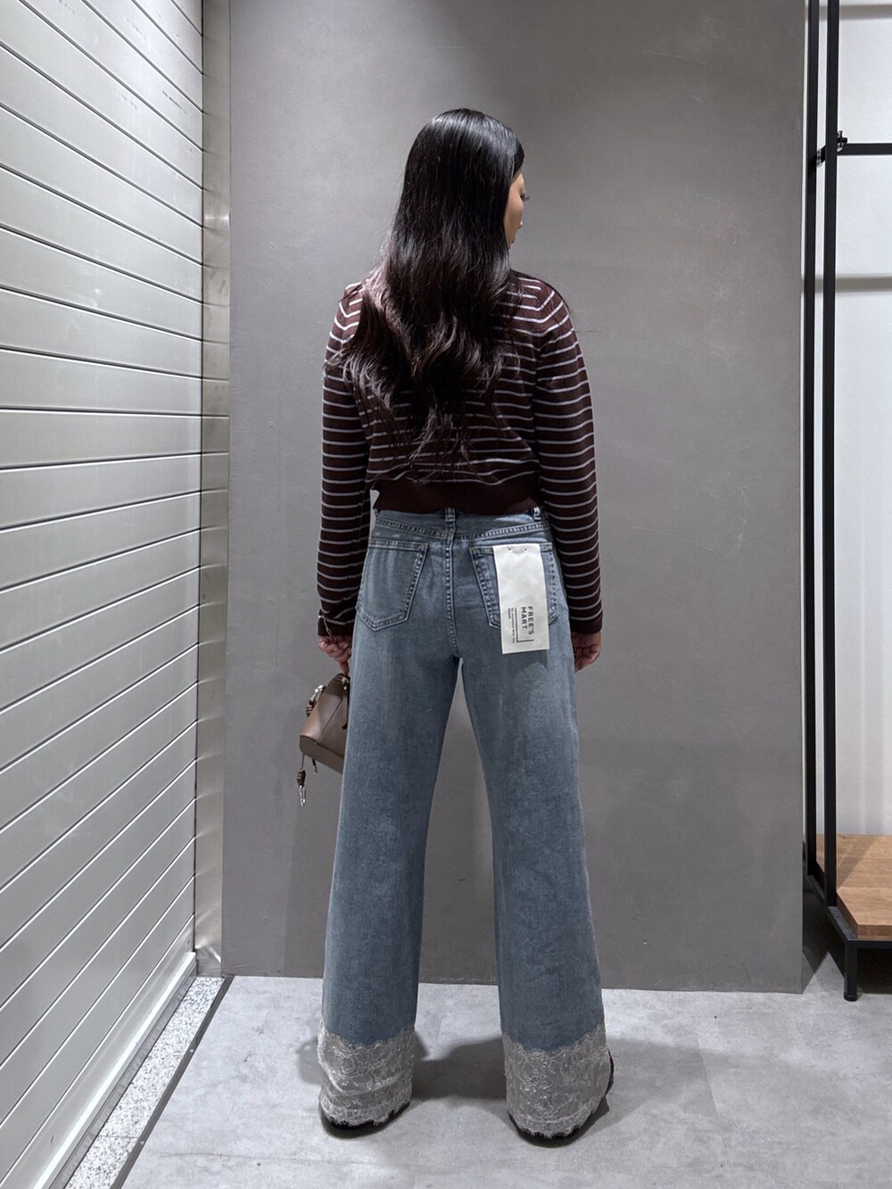 ブルー系のデニムパンツ、ブラウン系のニット/セーター、ブラウン系のローファーを着用したレディースの秋コーディネートの3枚目の写真