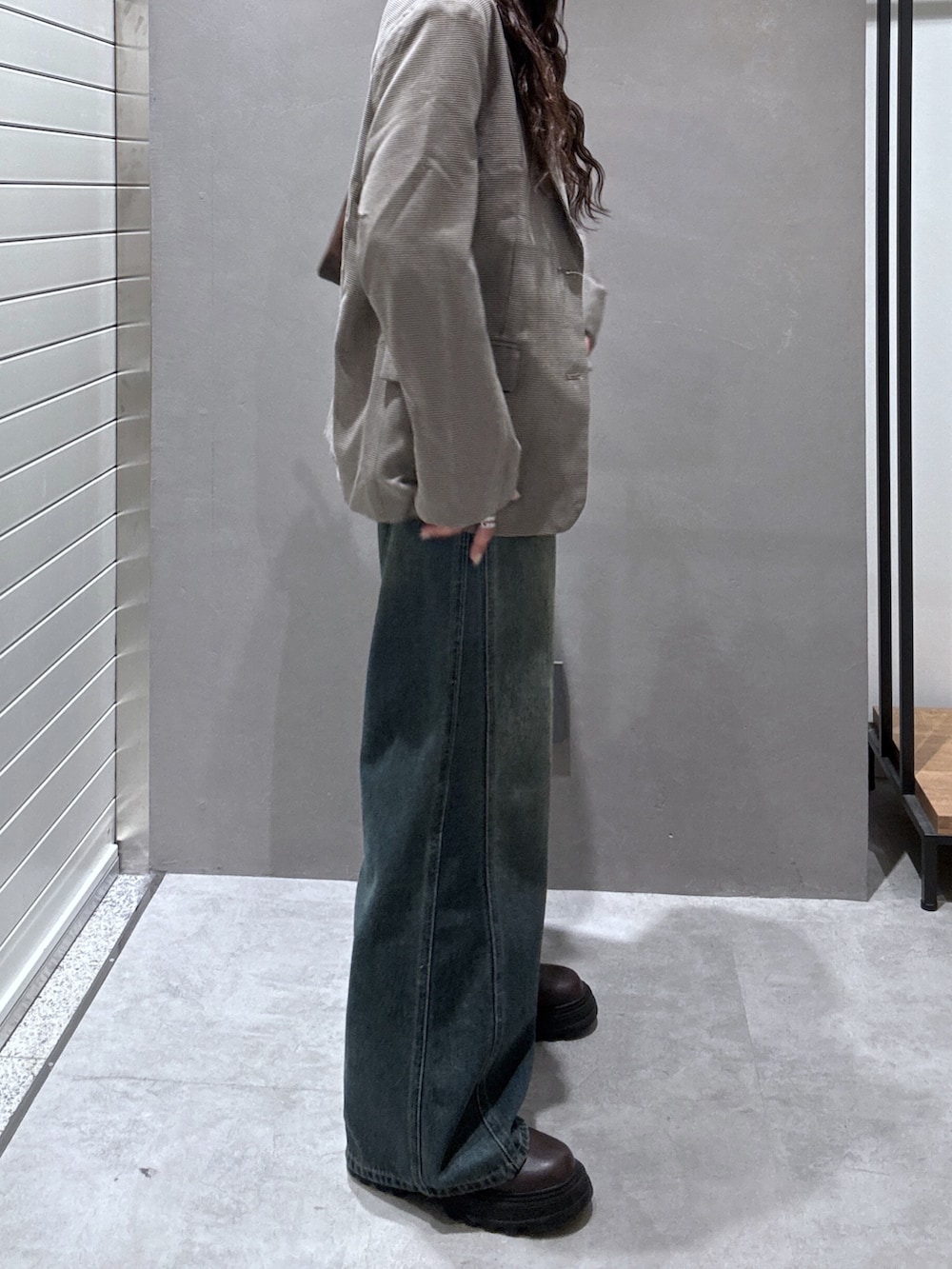 ブルー系のデニムパンツ、ベージュ系のテーラードジャケット、ブラウン系のTシャツ/カットソーを着用したレディースの秋コーディネートの2枚目の写真