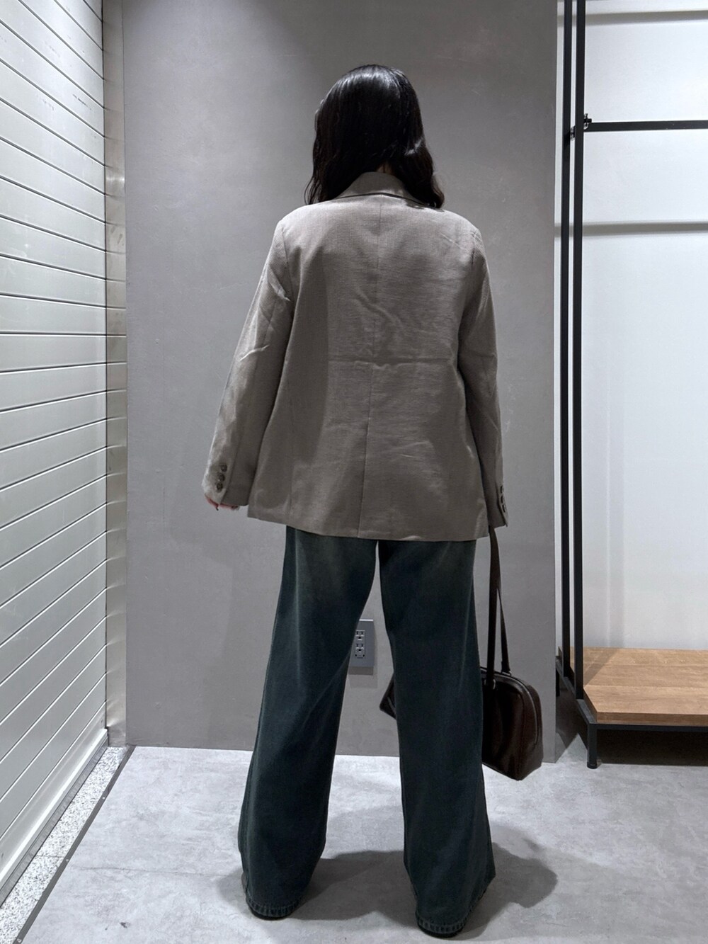 ブルー系のデニムパンツ、ベージュ系のテーラードジャケット、ブラウン系のTシャツ/カットソーを着用したレディースの秋コーディネートの3枚目の写真