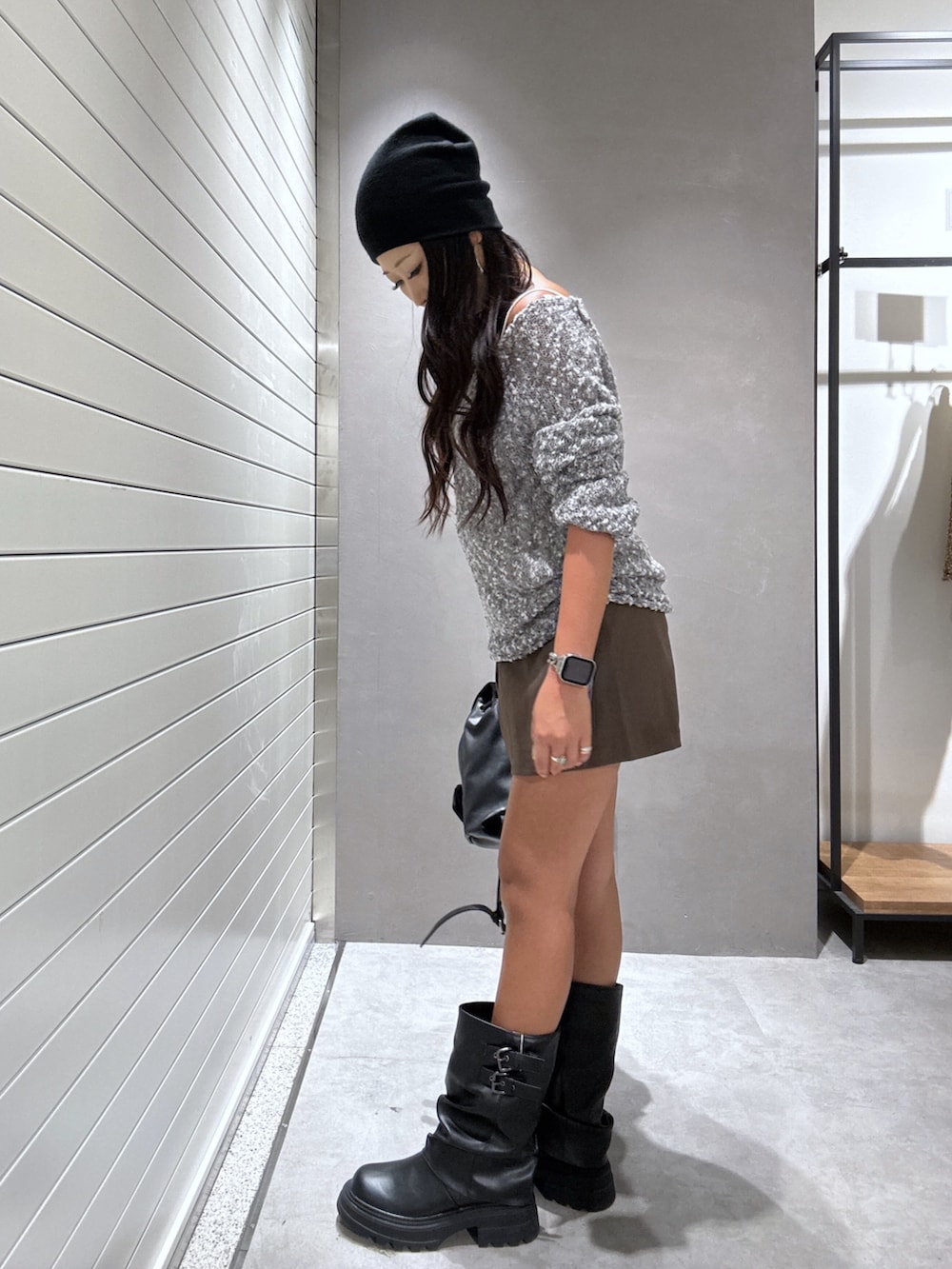 グレー系のニット/セーター、ブラウン系のその他パンツ、ブラック系のブーツを着用したレディースの秋コーディネートの2枚目の写真
