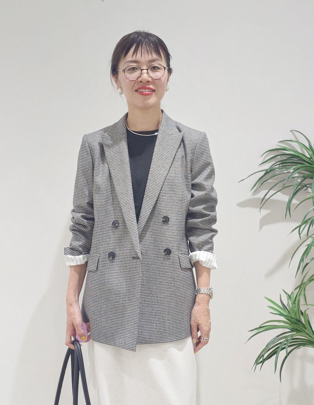 グレー系のテーラードジャケット、ブラック系のニット/セーター、ホワイト系のスカートを着用したレディースの夏コーディネートの9枚目の写真