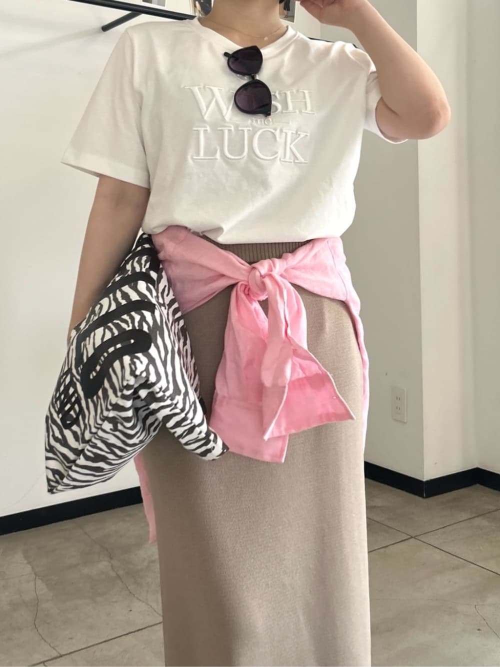 ホワイト系のTシャツ/カットソー、ベージュ系のスカート、その他のトートバッグを着用したレディースの春コーディネートの4枚目の写真