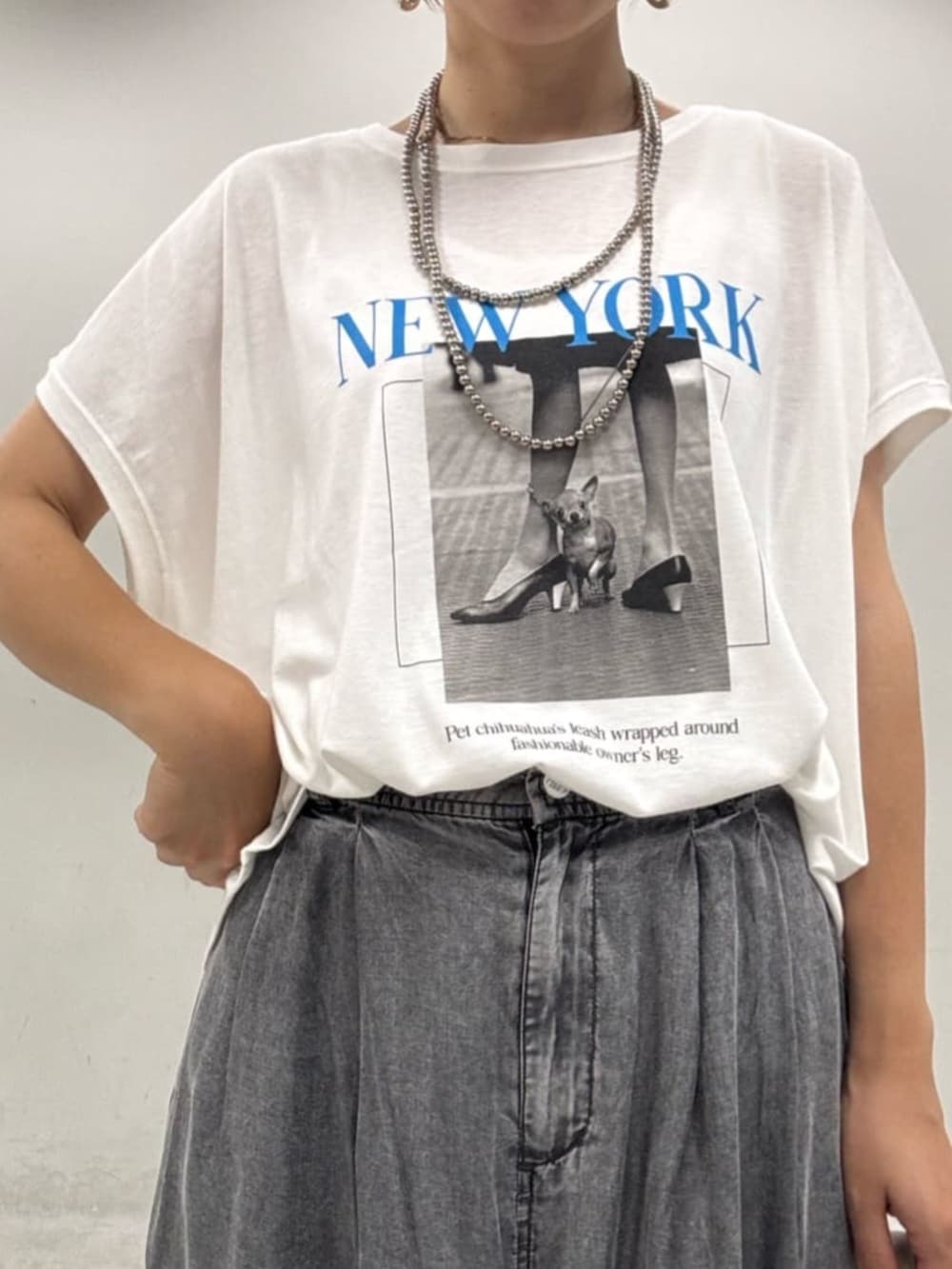 ホワイト系のショルダーバッグ、ブラック系のその他パンツ、ホワイト系のTシャツ/カットソーを着用したレディースの夏コーディネートの2枚目の写真