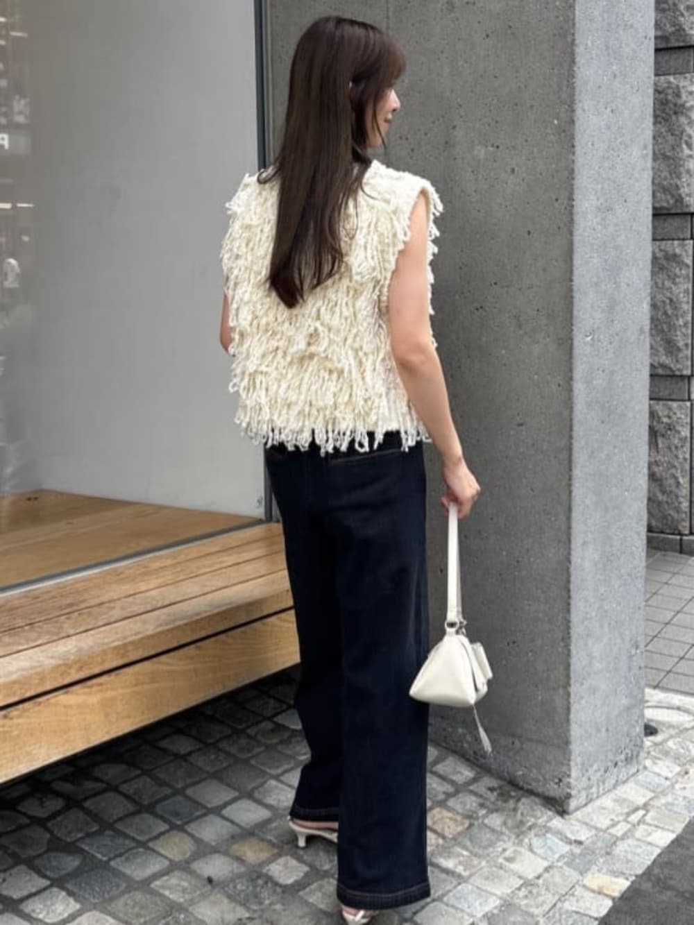 ホワイト系のショルダーバッグ、ブルー系のデニムパンツを着用したレディースの夏コーディネートの4枚目の写真