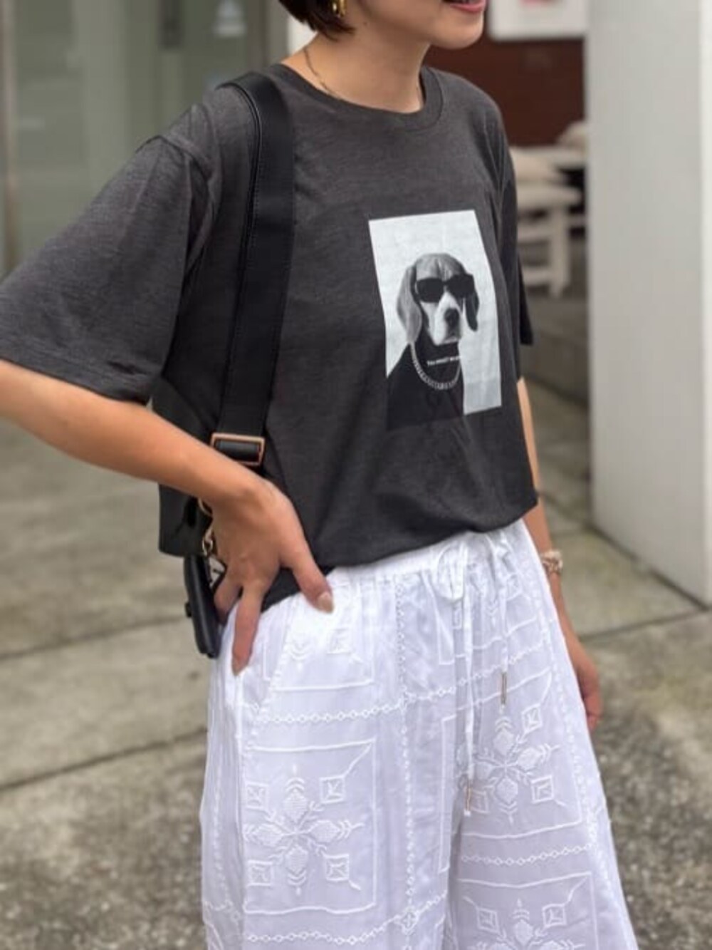 ブラック系のショルダーバッグ、ホワイト系のその他パンツ、その他のTシャツ/カットソーを着用したレディースの夏コーディネートの4枚目の写真