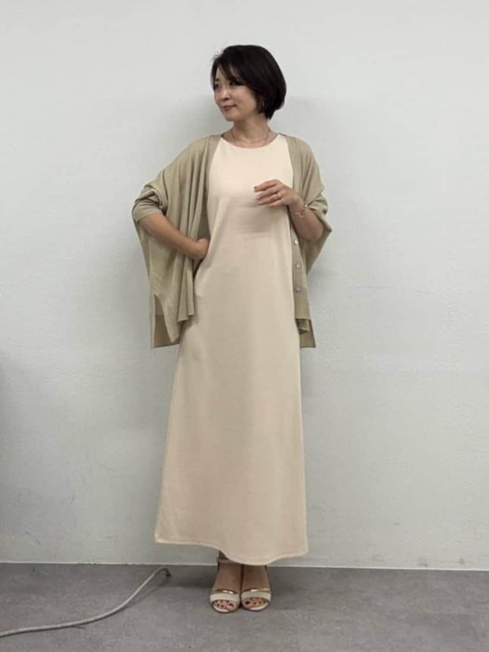 ベージュ系のカーディガン/ボレロ、ホワイト系のワンピースを着用したレディースの春コーディネートの2枚目の写真