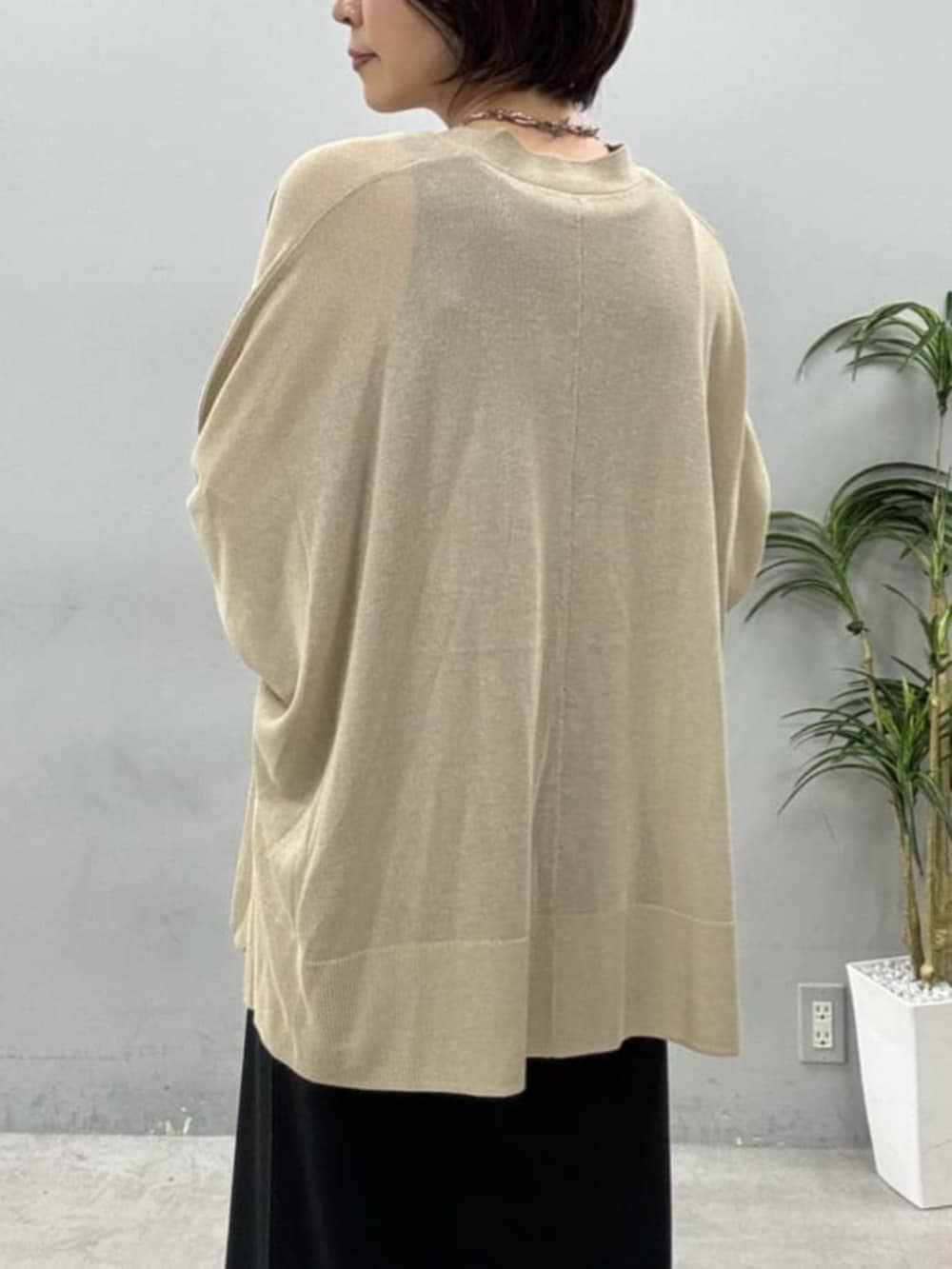 ブラック系のワンピース、ベージュ系のカーディガン/ボレロを着用したレディースの春コーディネートの4枚目の写真