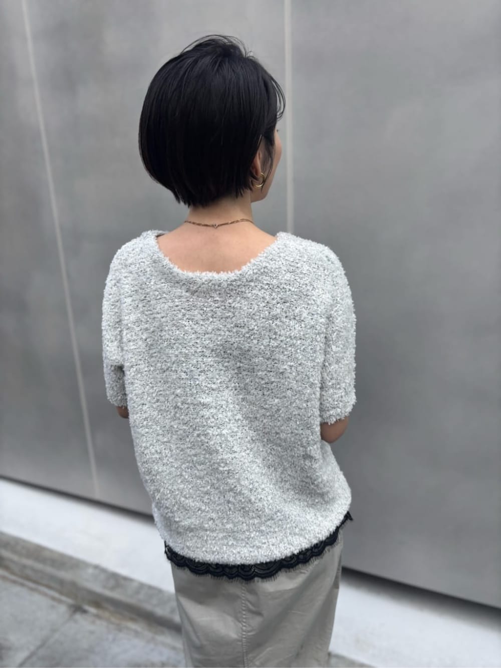 ブラック系のキャミソール、ベージュ系のスカート、ブラック系のショルダーバッグを着用したレディースの春コーディネートの4枚目の写真