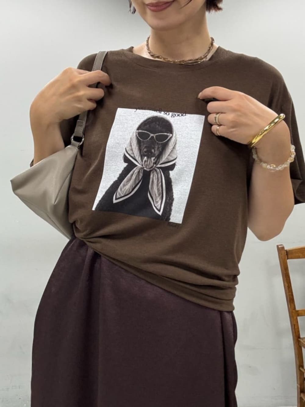 ベージュ系のショルダーバッグ、ブラウン系のTシャツ/カットソー、ブラウン系のワンピースを着用したレディースの夏コーディネートの2枚目の写真