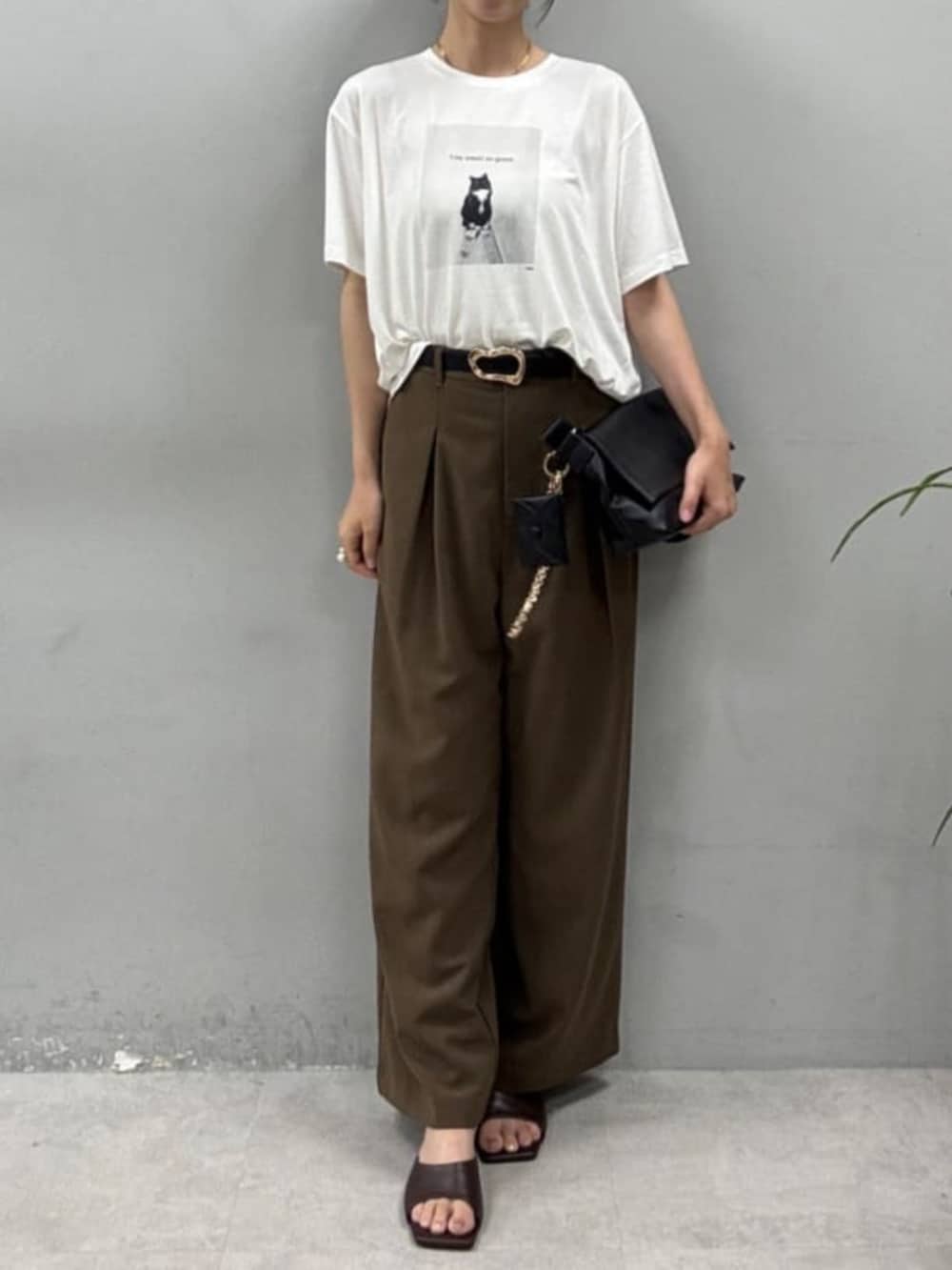 ブラウン系のスラックス、ブラウン系のショルダーバッグ、その他のTシャツ/カットソーを着用したレディースの夏コーディネートの3枚目の写真